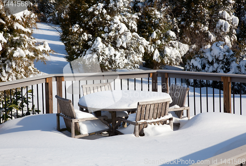 Image of Snowy modern deck with wooden table