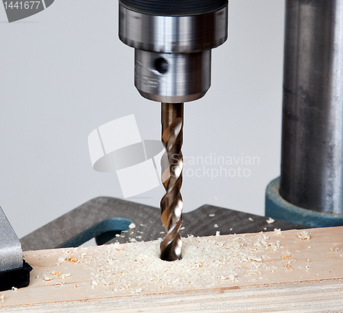 Image of Close up of drill bit above wood