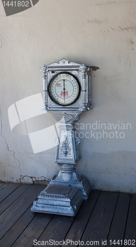 Image of Old weigh scale against white wall