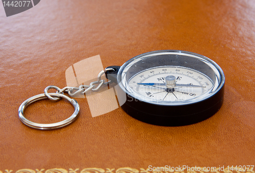 Image of Old compass on leather desk