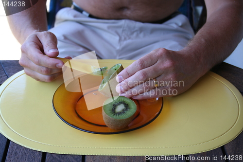 Image of Man eating kiwi