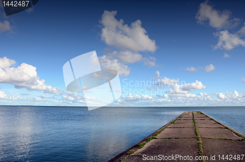 Image of Concrete pier or bridge in sea. Calm sea water.