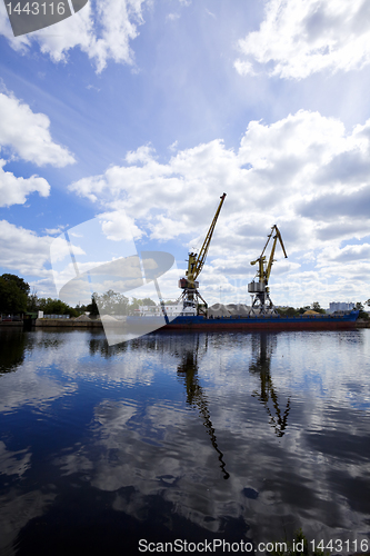 Image of crane silhouette on dock and river