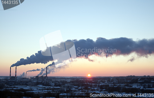 Image of winter industrial sunset with smoke