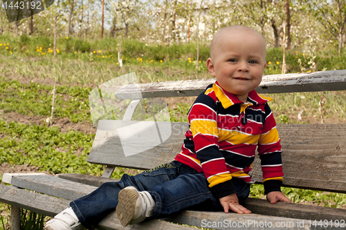 Image of A boy sitting on a bench