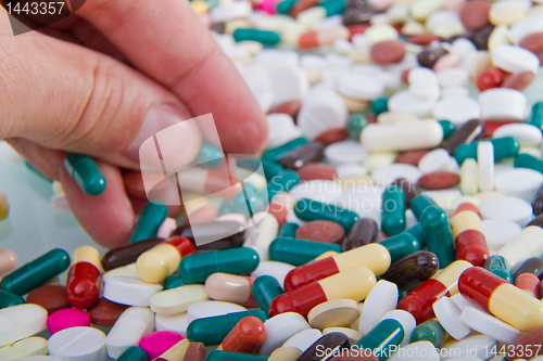 Image of hand grabbing pills