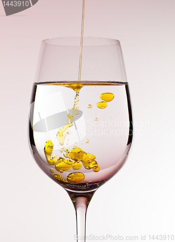 Image of Olive oil being poured into wine glass