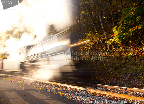 Image of Steam train powers along railway