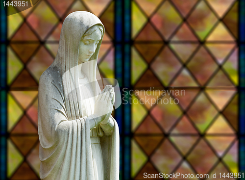 Image of Isolated statue of Mary against window