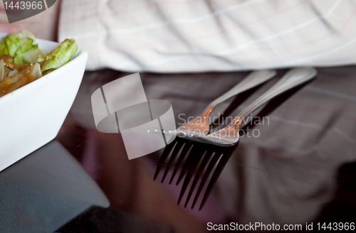 Image of Pair of forks reflecting from dinner table