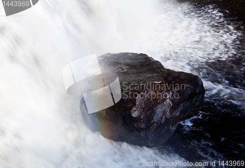 Image of Rainbow over rock in waterfall