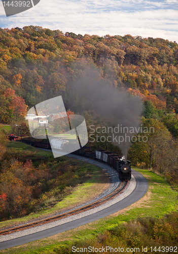Image of Steam train powers along railway
