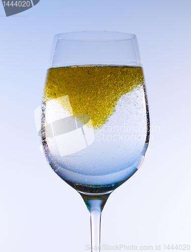 Image of Olive oil stirred into wine glass