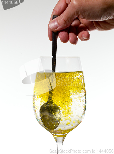 Image of Olive oil being stirred in wine glass