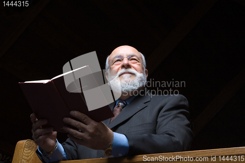Image of Hansom Senior Caucasian Man Holding a Hymnal in Church Pew 