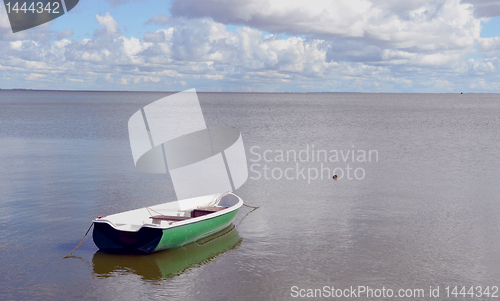 Image of Lonely plastic boat tied near quiet lake shore.