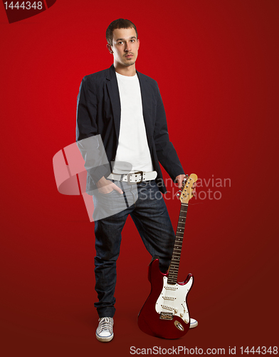 Image of stylish man with guitar looking at camera