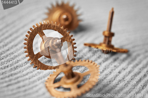 Image of Watch gears on sand - abstract still life