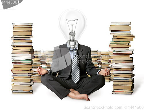 Image of businessman in lotus pose and lamp-head with many books near