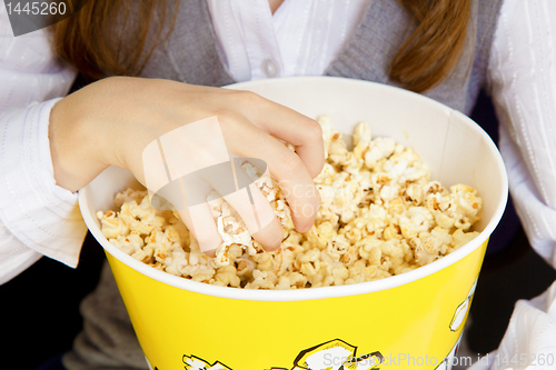 Image of hand in a bucket of popcorn