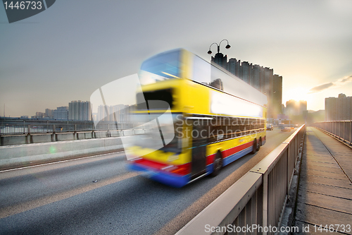 Image of speed bus through sunset road