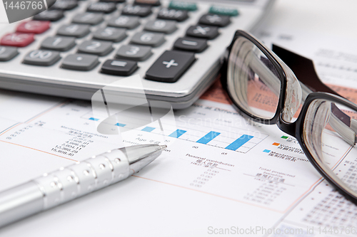 Image of Stock chart with calculator,pen and eyeglasses 