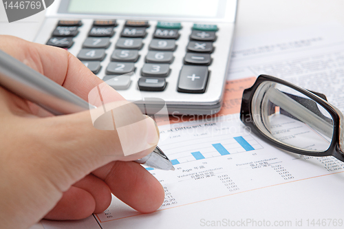 Image of Stock chart with calculator,pen and eyeglasses 