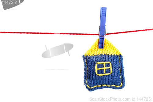 Image of knitted house on a red string