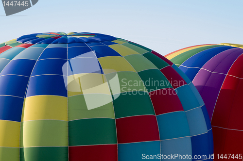 Image of Top sections of hot-air balloons inflating or ascending