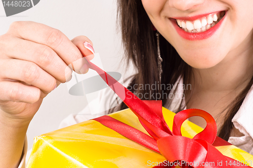 Image of Attractive girl with a cheerful expression opening her christmas