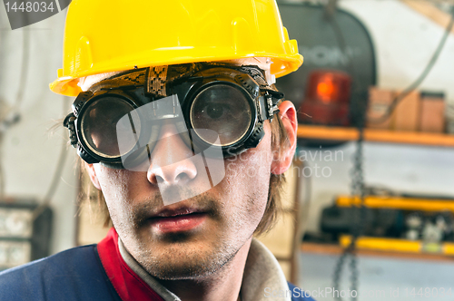 Image of Closeup of an industrial worker in yellow helmet