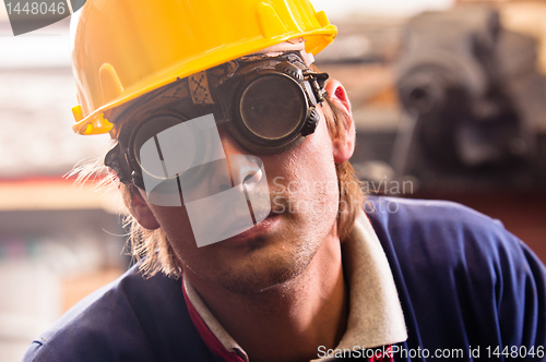 Image of Closeup of an industrial worker in yellow helmet