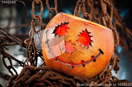 Image of Halloween pumkin cought in the web of chains