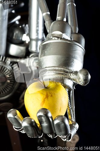 Image of A robot hand with green apple