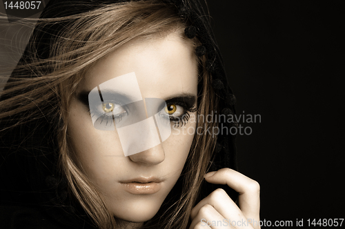 Image of An attractive beautiful girl in hood against black background