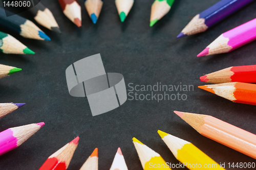 Image of Colorful pencils on dark background in a circle