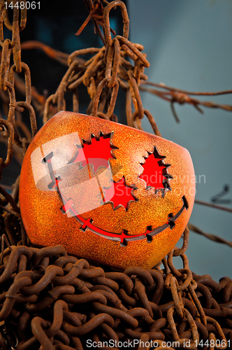 Image of Halloween pumkin cought in the web of chains