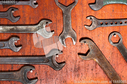 Image of Used spanners on red wooden board