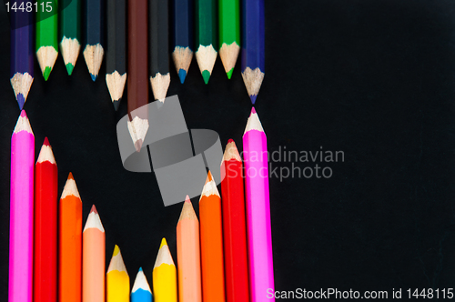 Image of Colored pencils in heart shape on white