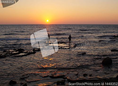 Image of fishers in a sunset sea