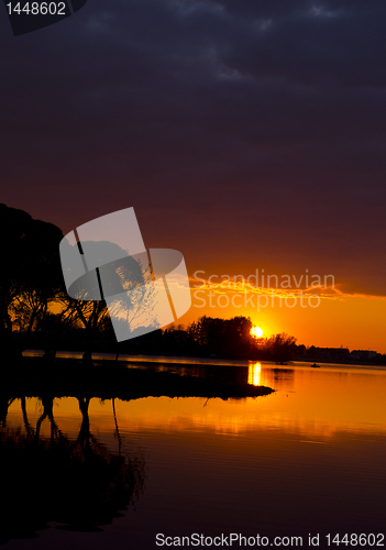 Image of Amazing landscape view of sunset lake and boat.