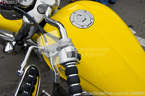 Image of Motorcycle wheel and yellow petrol tank details.