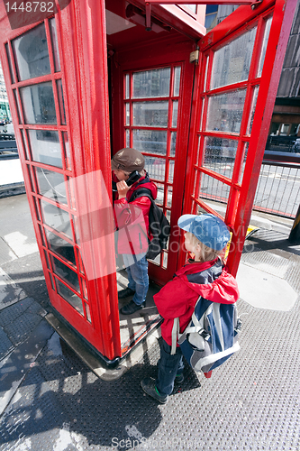 Image of Boy talking in pay phone box