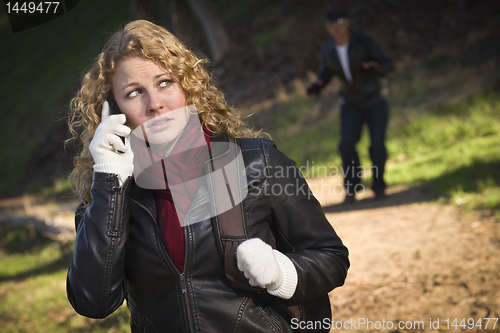 Image of Pretty Young Teen Girl Walking with Man Lurking Behind Her