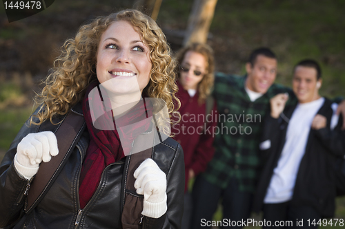 Image of Pretty Young Teen Girl with Boys Behind Admiring Her