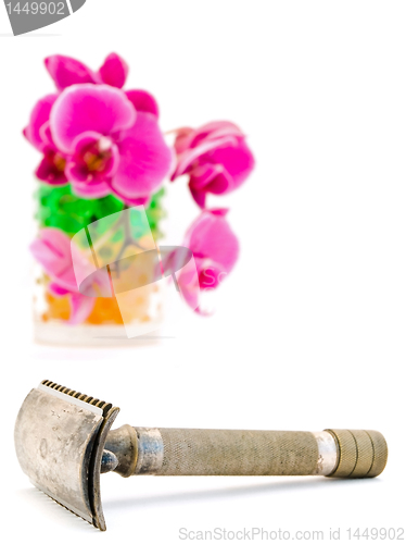 Image of orchid in glass and shave razor