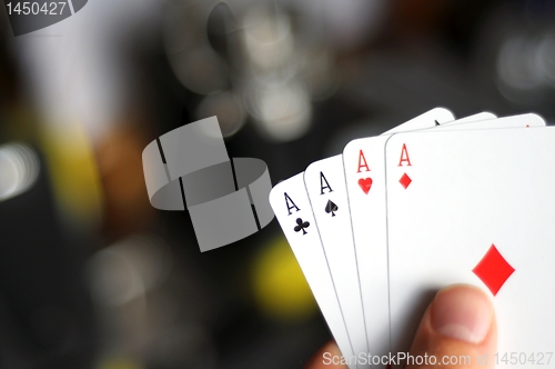 Image of hand holding four aces