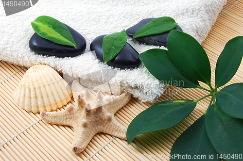 Image of foldet white bath towel and zen stones