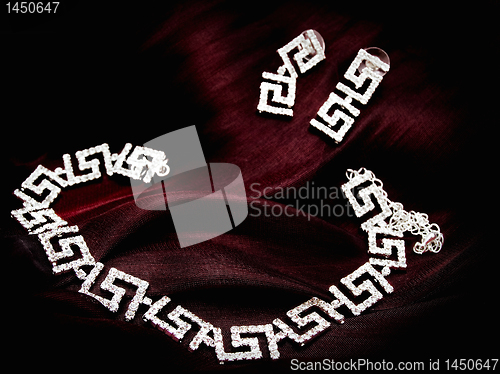 Image of necklace earrings at red fabric