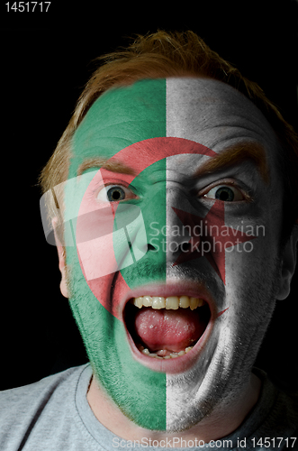 Image of Face of crazy angry man painted in colors of algeria flag